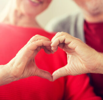 Para seniorów pokazująca symbol serca